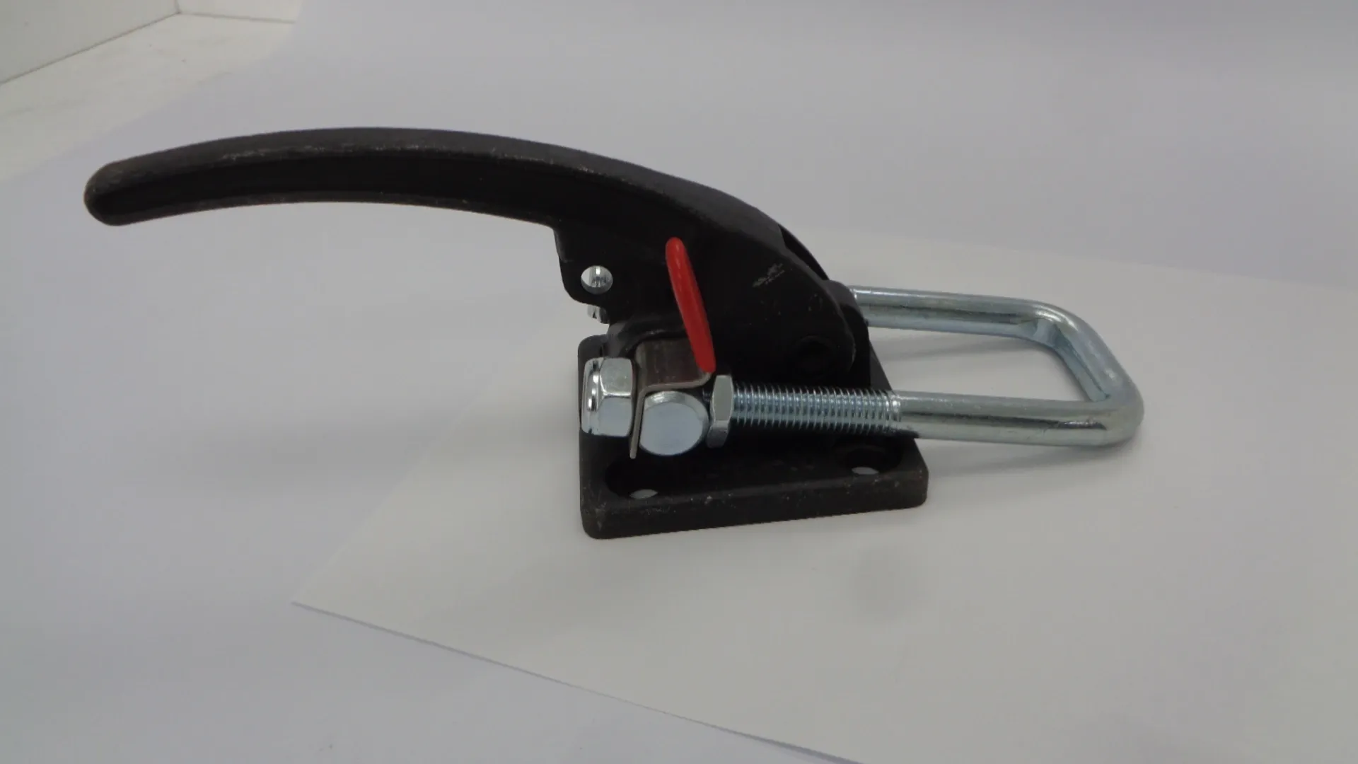 Close-up of a metal tension tool with a red lever.