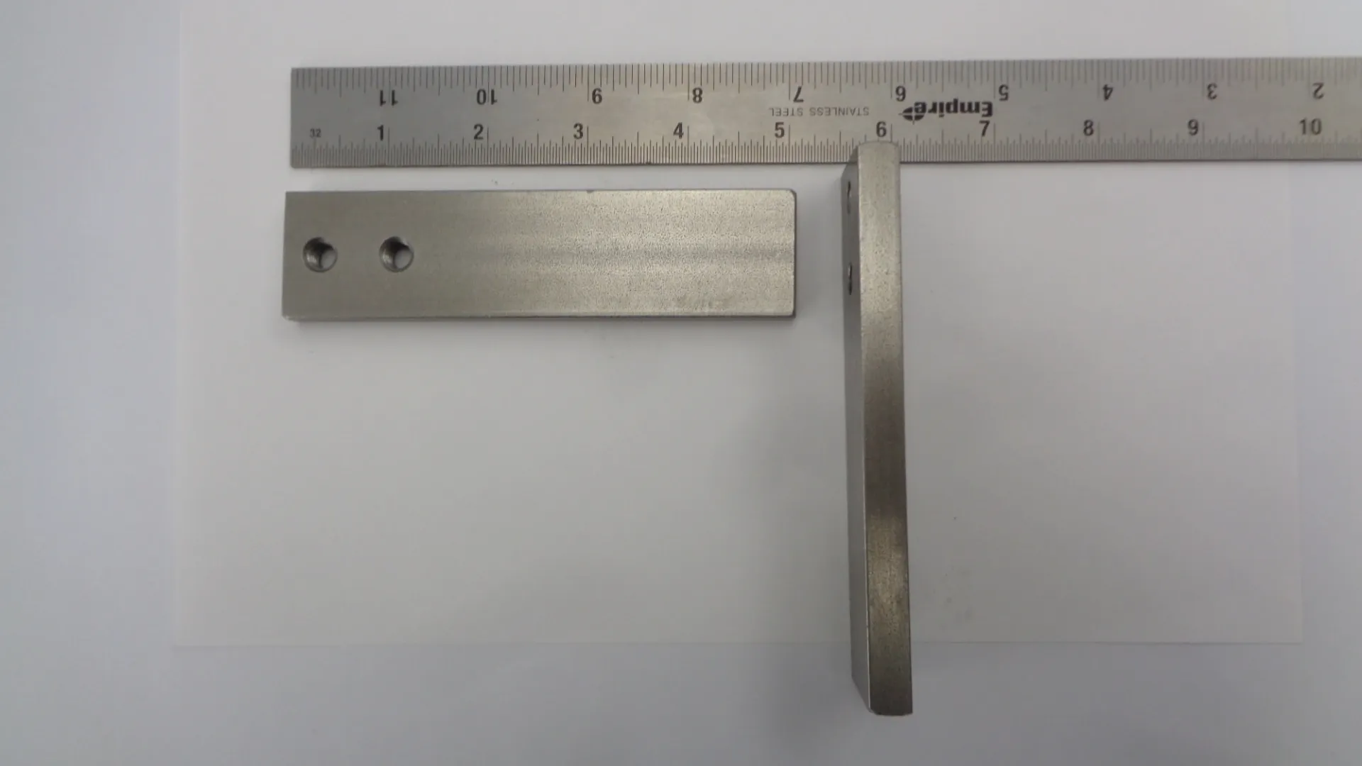 A stainless steel square ruler with measurements and a perpendicular arm.