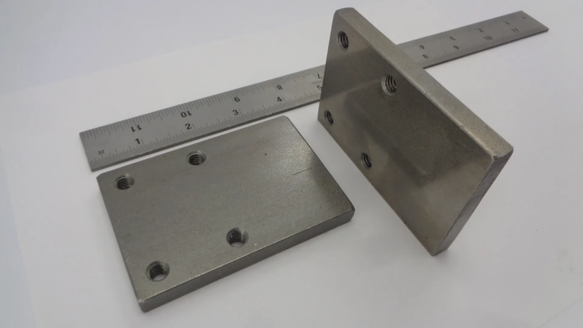 Two rectangular metal brackets with holes for mounting.