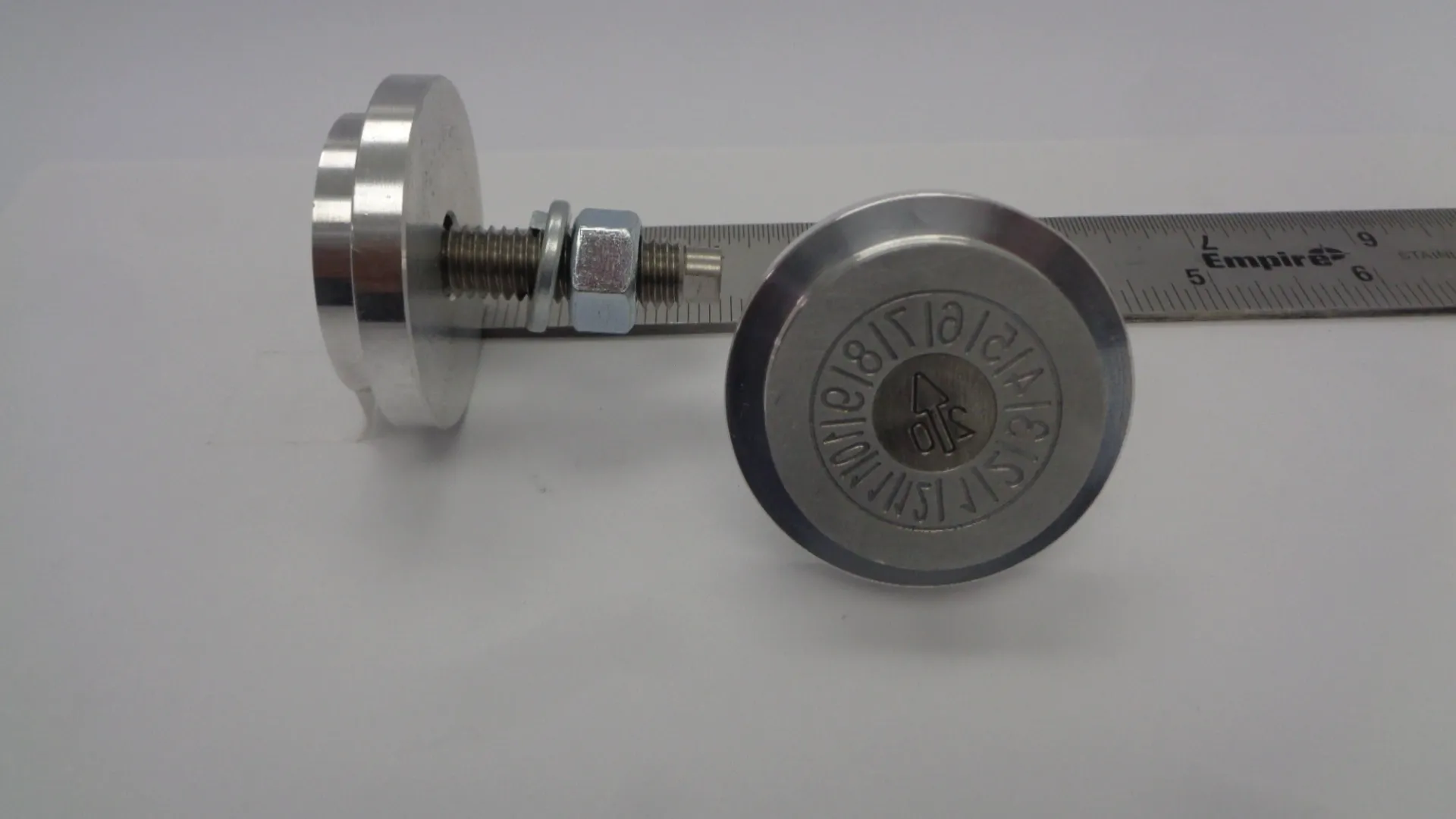 Close-up of a stainless steel pressure gauge with engraved markings.