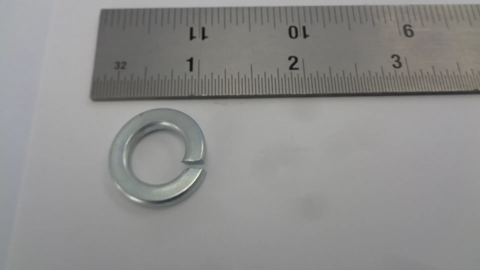 A metal washer placed below a measuring ruler.